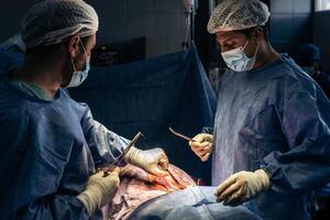 médicos costura uma pacientes costas depois de cirurgia foto
