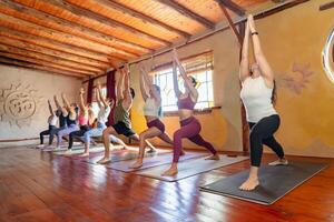 grupo do latim pessoas levando ioga classe dentro uma ioga estúdio foto