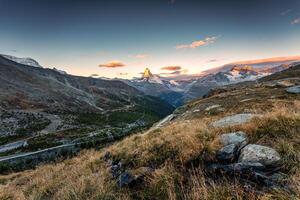 nascer do sol sobre matterhorn montanha em Prado e corrente fluindo às zermatt, Suíça foto