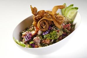 deliciosa salada fattoush ou árabe com croutons de pita, legumes frescos e ervas, na chapa branca. Salada de pão do Oriente Médio. receita autêntica fácil e saudável. foto