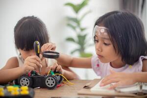 inventivo crianças aprender às casa de codificação robô carros e eletrônico borda cabos dentro tronco. construindo robô carros às casa foto