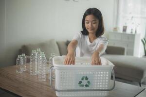 ásia pequeno meninas separando reciclar plástico garrafas para Lixo bin. foto