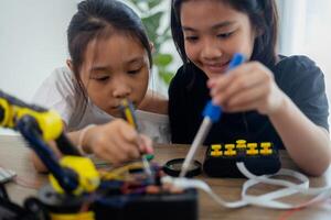 inventivo crianças aprender às casa de codificação robô carros e eletrônico borda cabos dentro tronco. construindo robô carros às casa foto