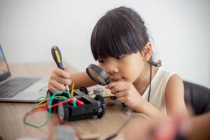 inventivo crianças aprender às casa de codificação robô carros e eletrônico borda cabos dentro tronco. construindo robô carros às casa foto