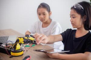 inventivo crianças aprender às casa de codificação robô carros e eletrônico borda cabos dentro tronco. construindo robô carros às casa foto