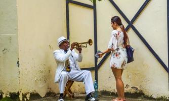 havana, cuba, 4 de julho de 2017 - homem não identificado tocando trompete na rua de havana, cuba. músicos de rua são comuns em havana, onde tocam música para turistas. foto