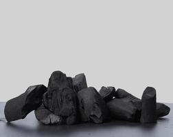 carvão vegetal. carvão preto no piso texturizado preto. usado para cozinhar foto