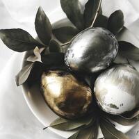 ai gerado decoração com dourado e prata Páscoa ovos com folhas foto