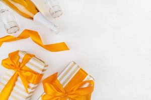 presentes de natal embrulhados com papel dourado e branco, champanhe e taças vista de cima plana lay