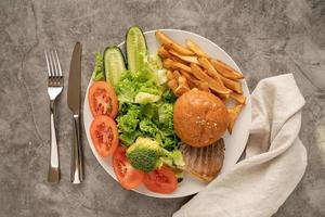 vegetabés e fast food em um prato vista de cima plana lay foto