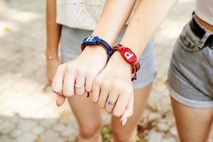 duas amigas mostrando as mãos com pulseiras da amizade foto
