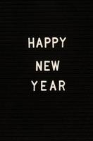 as palavras feliz ano novo no quadro de feltro preto foto