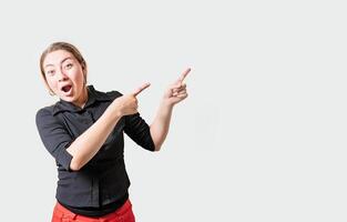 espantado menina apontando a publicidade lado. atônito menina apontando para uma bandeira para a lado. pessoas apontando uma promo foto