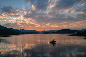 o lago noturno refletia o brilho do pôr do sol e as montanhas foto