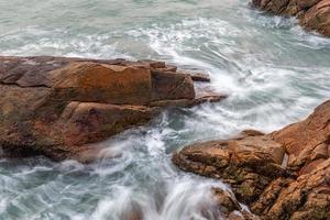 rochas e ondas à beira-mar foto