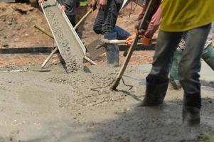 trabalhadores despejam concreto para construção. foto