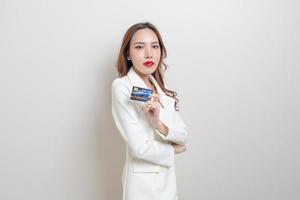 retrato linda mulher asiática segurando um cartão de crédito foto