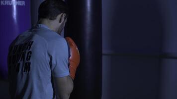 açao do uma boxe marcial artes lutador Treinamento em uma soco saco dentro a academia. boxer Treinamento com soco saco foto