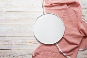 a placa branca na toalha de mesa rosa na vista de cima da mesa de madeira foto