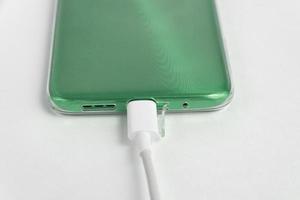 telefone celular verde conectado ao cabo usb tipo c - carregando foto