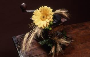 uma flor e alguns pinho cones em uma mesa foto