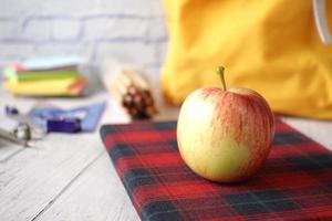 preto para o conceito de escola com a maçã no bloco de notas na mesa. foto