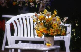 uma vaso do flores em uma cadeira foto