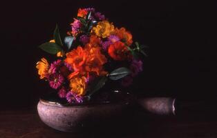 uma vaso preenchidas com flores sentado em uma mesa foto