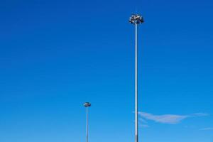 luz pólos, cópia de espaço. conduziu luz postar para estacionamento muito, azul céu fundo. poste de iluminação para rua iluminação às noite. foto