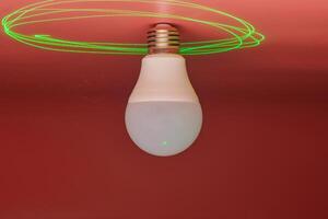 lâmpada e feixe de laser verde ao redor, economia de energia. conceito de ideia mínima. foto