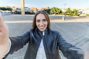 sorridente jovem mulher levando uma selfie dentro a cidade foto