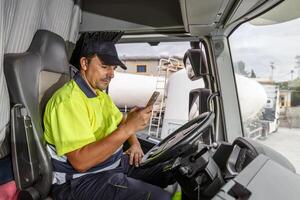 masculino motorista usando Smartphone dentro caminhão foto