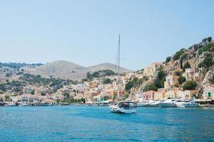 iate chegando ao porto de Symi. vista da vila colorida em um dia de verão. Grécia foto