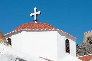 bela torre branca com uma cruz ortodoxa no topo. lindos, rhodes, grécia foto