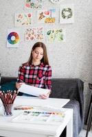 bela mulher artista pintando um quadro em casa foto