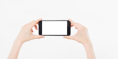 mão segurando o telefone móvel horizontal isolado no fundo branco, tela em branco vazia foto