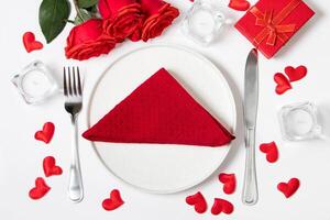 mesa configuração para dia dos namorados dia. vermelho rosas e talheres em uma branco fundo. foto