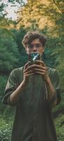 ai generativo feliz jovem homem levar uma selfie em uma excursão dentro a floresta às verão bonito cara levando uma auto retrato com dele Smartphone foto