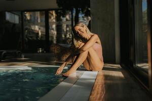 jovem mulher relaxante de a interior natação piscina foto