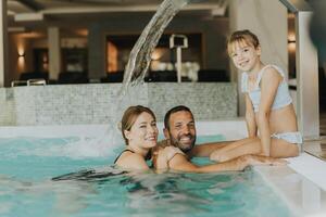 família dentro a interior natação piscina foto