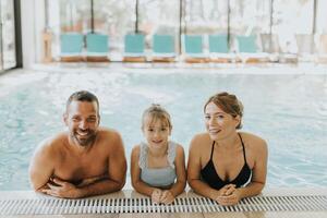 família dentro a interior natação piscina foto