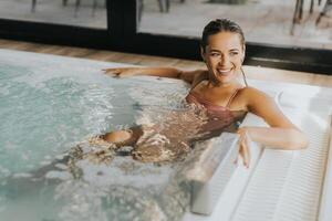 jovem mulher relaxante dentro a interior bolha piscina foto