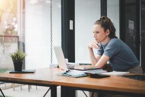 sério ocupado jovem o negócio mulher Gerente executivo olhando às computador portátil computador pensando do financeiro digital mercado riscos, considerando Novo corporativo estratégia ideia, assistindo webinário. foto