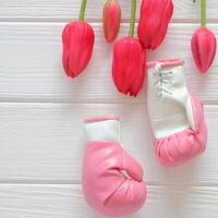 tulipas flores e boxe luvas em de madeira fundo, feminismo conceito foto