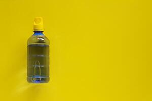 água garrafa em amarelo fundo foto
