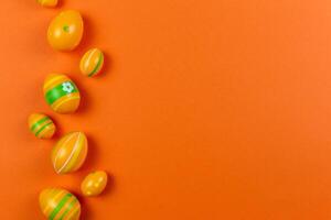 colorida Páscoa pintado ovos em laranja fundo. Páscoa feriado plano deitar conceito. tradicional decoração para primavera feriados. topo visualizar. cópia de espaço. foto