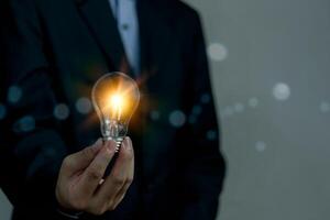 mão segurando luz lâmpada ideia. inovação desenvolvimento conhecimento Aprendendo e Educação foto