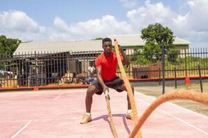 Atlético bonito africano homem fazendo treinamento cruzado foto