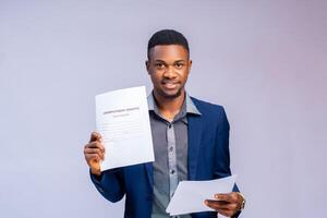 bonito africano homem de negocios segurando uma benefício Formato e sorridente foto