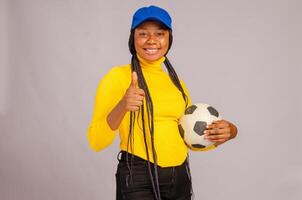 jovem futebol segurando bola sorridente e fez polegares acima foto